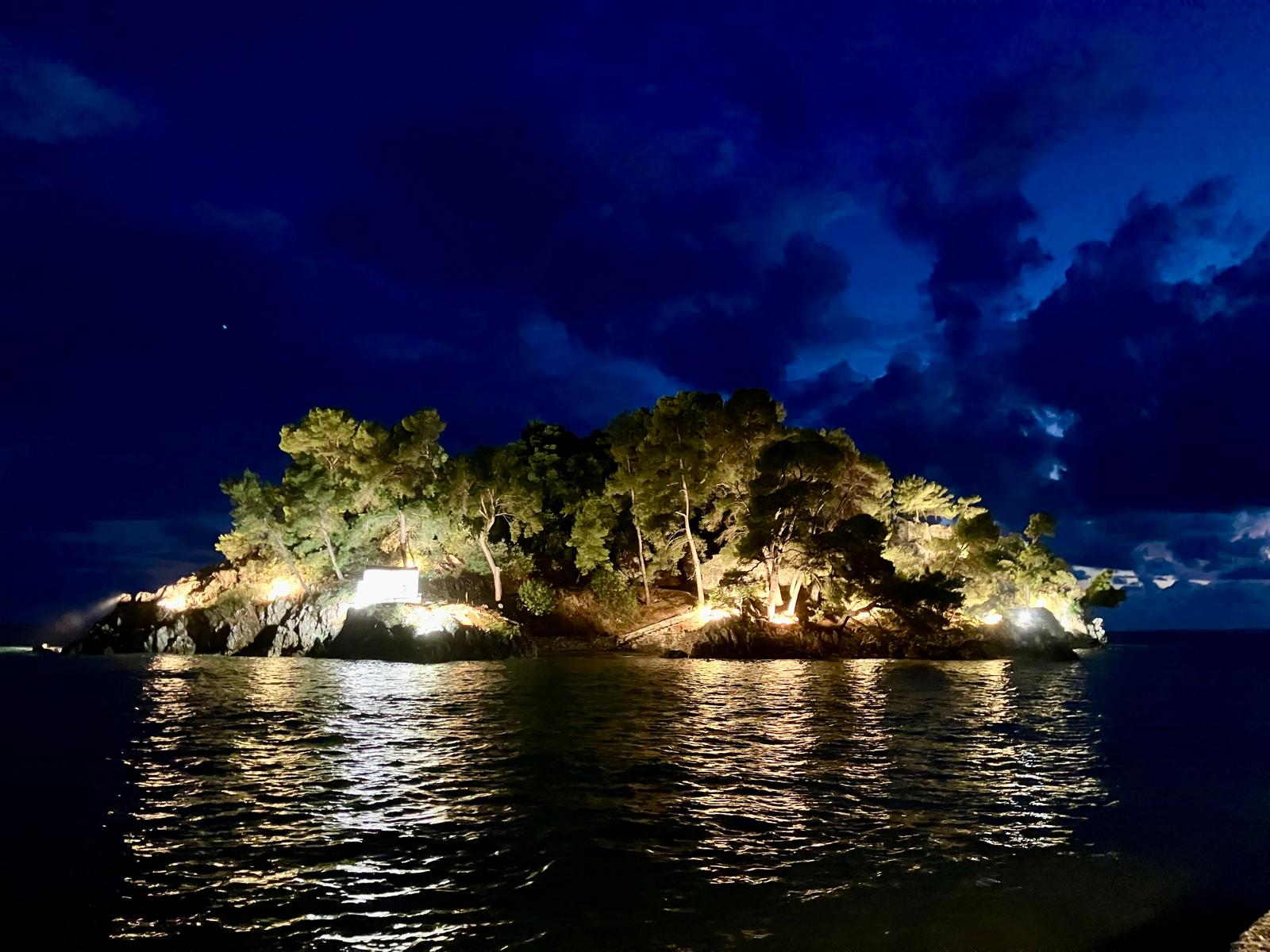 The harbour in the evening, with fishing boats and the lights of the waterfront.